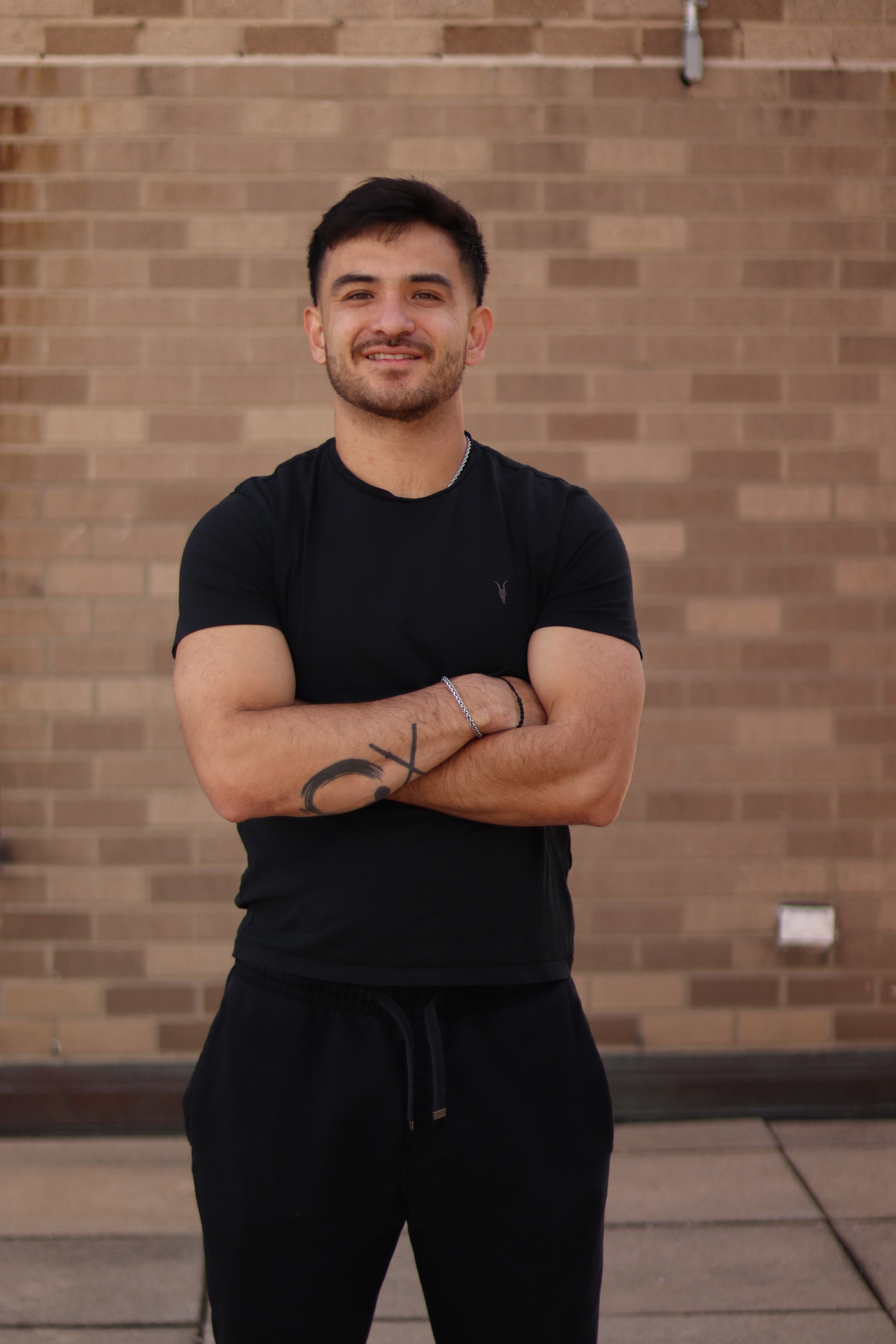 Alex Dea Jue standing with arms crossed